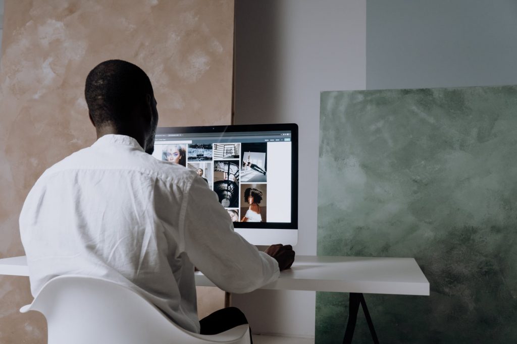 man browsing pexels on an imac